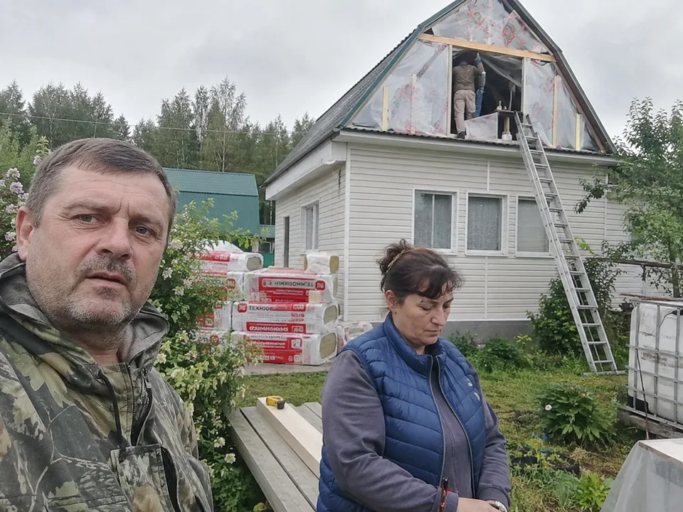Люди рядом с домом во время утепления мансарды